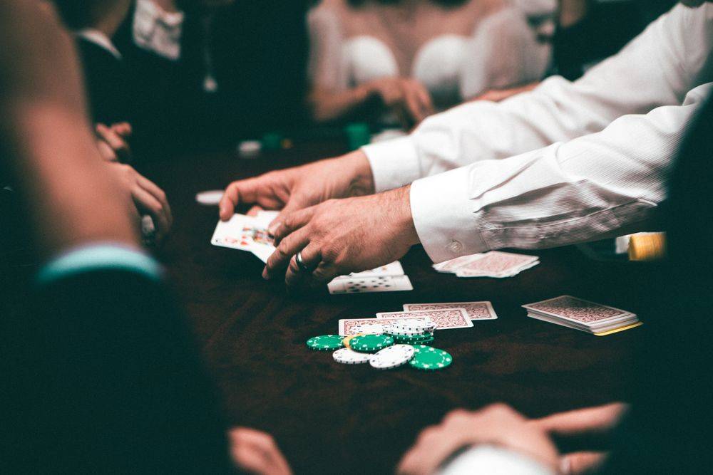 Suasana meja permainan kartu dengan tumpukan chip kasino